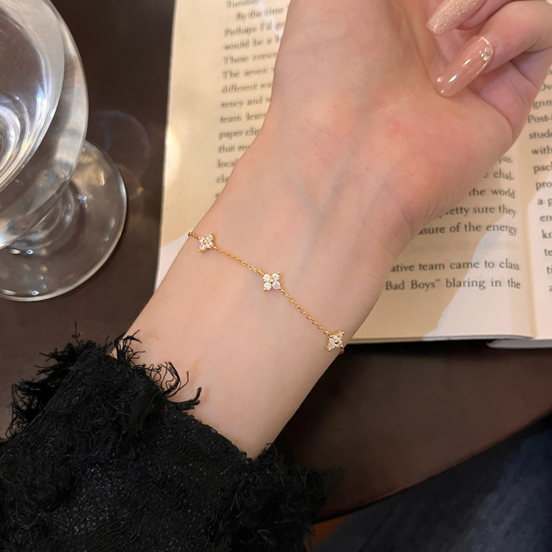 Gold finish S925 silver four leaf clover CZ station bracelet worn on wrist